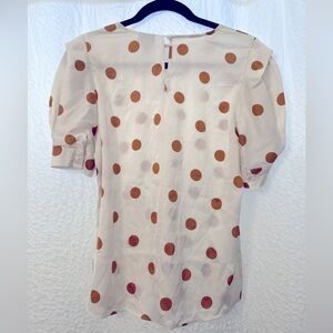 satin white blouse with orange polka dots.